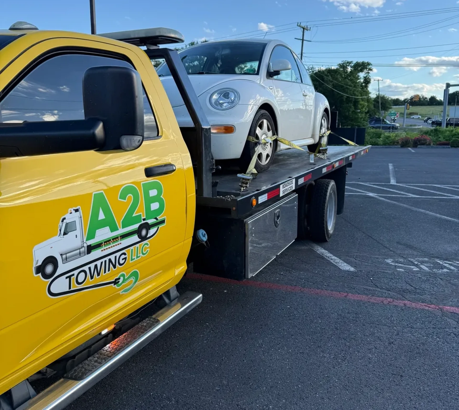 Tow truck carrying a white car.