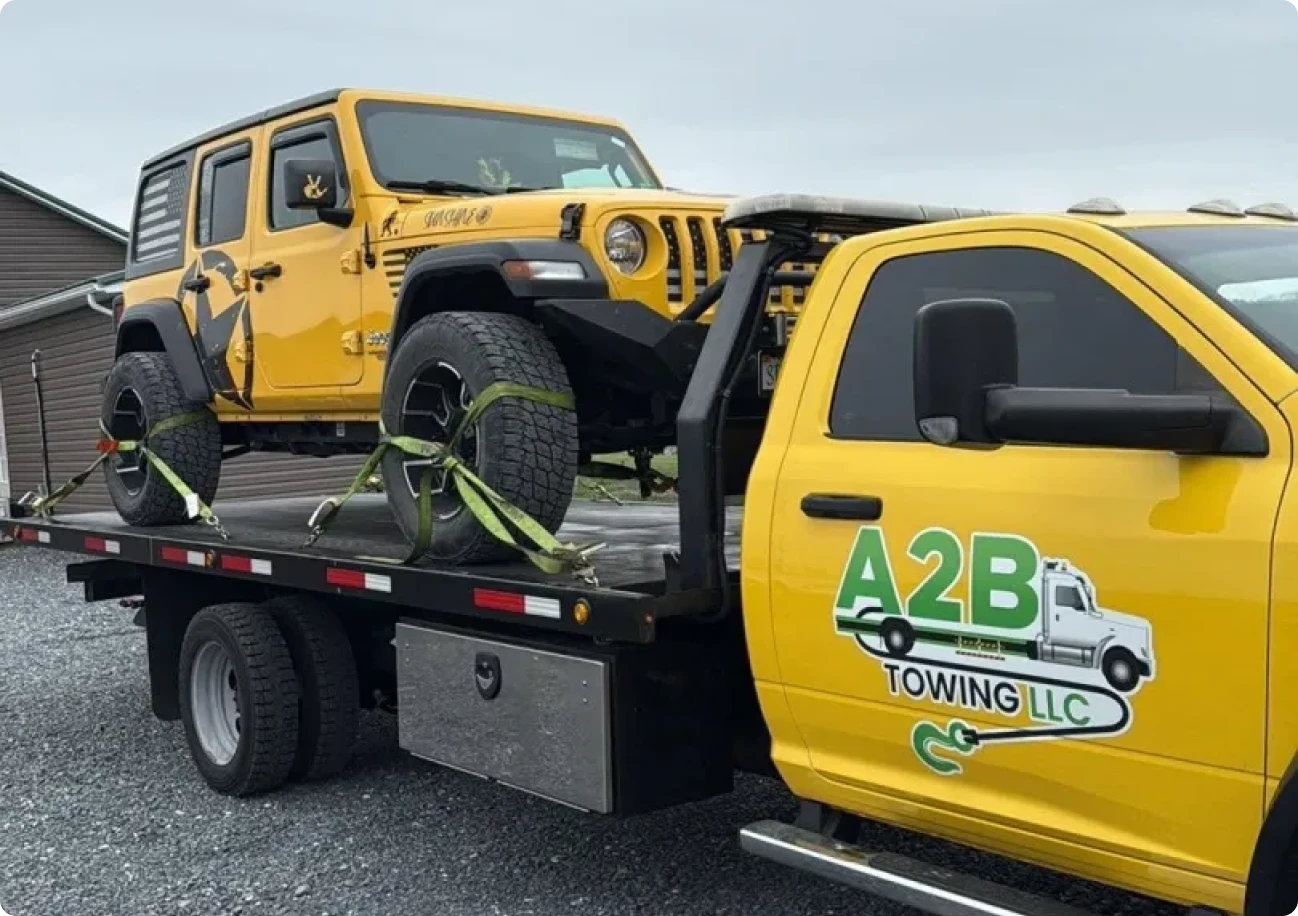 Tow truck carrying a yellow Jeep.