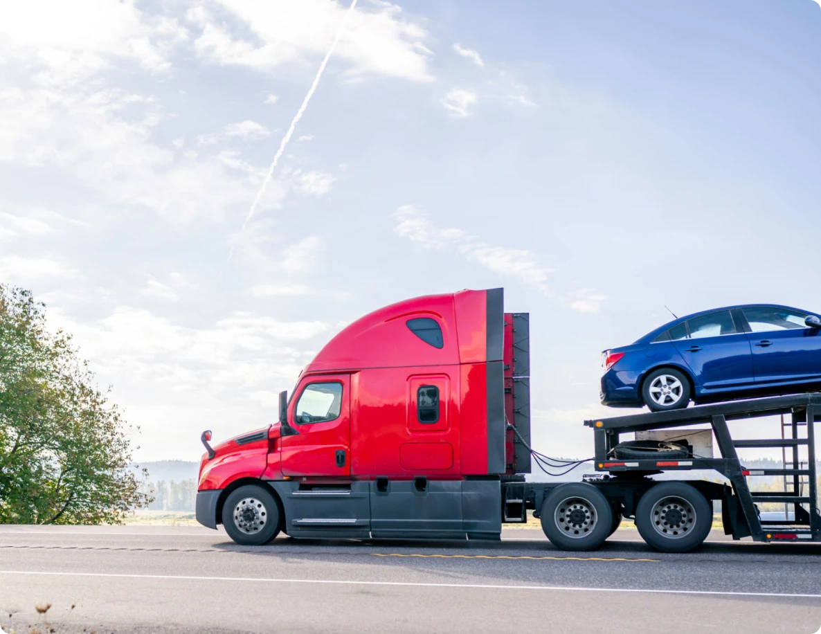 Red truck transporting a blue car.