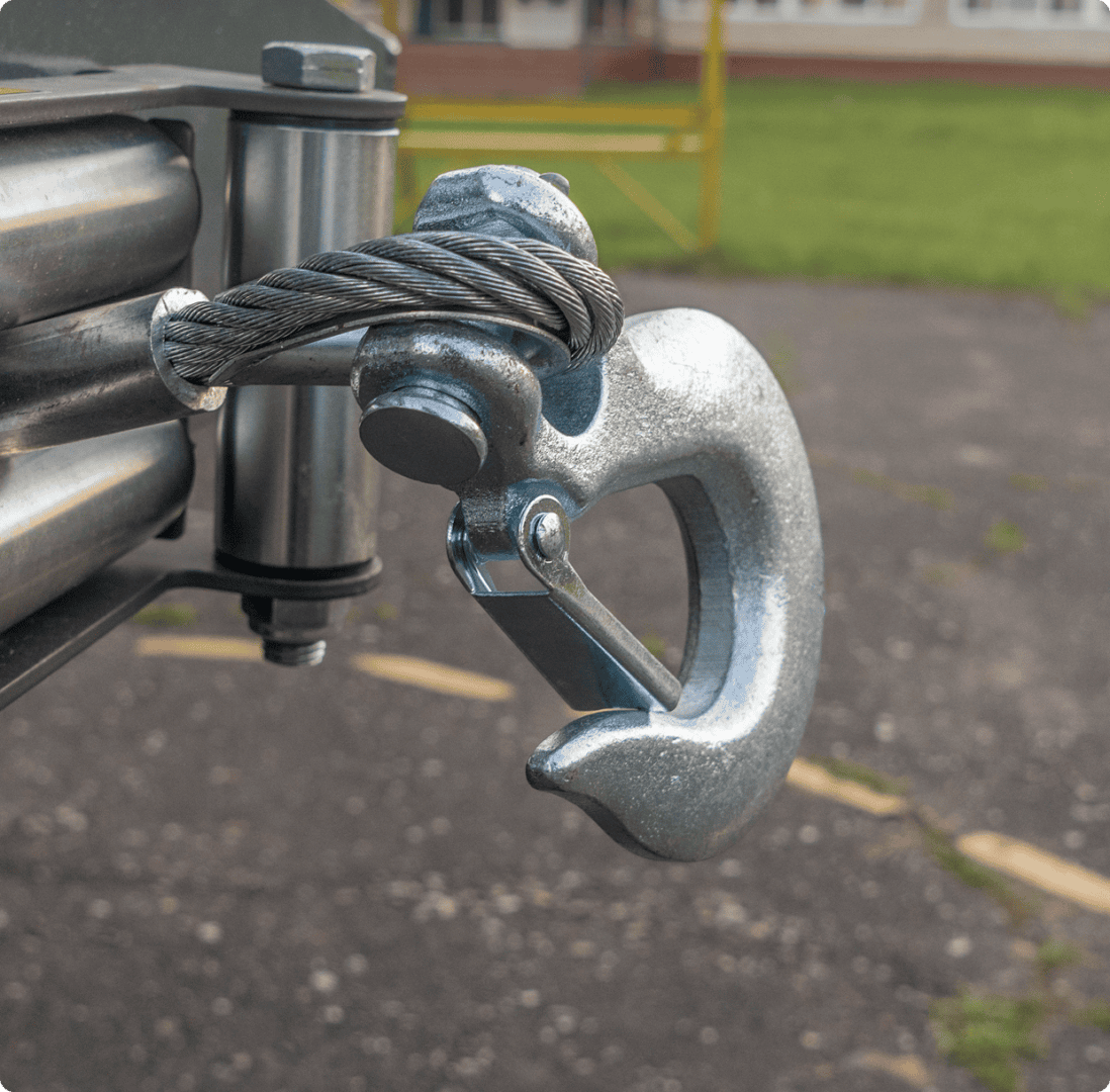 Metal hook with coiled cable outdoors.