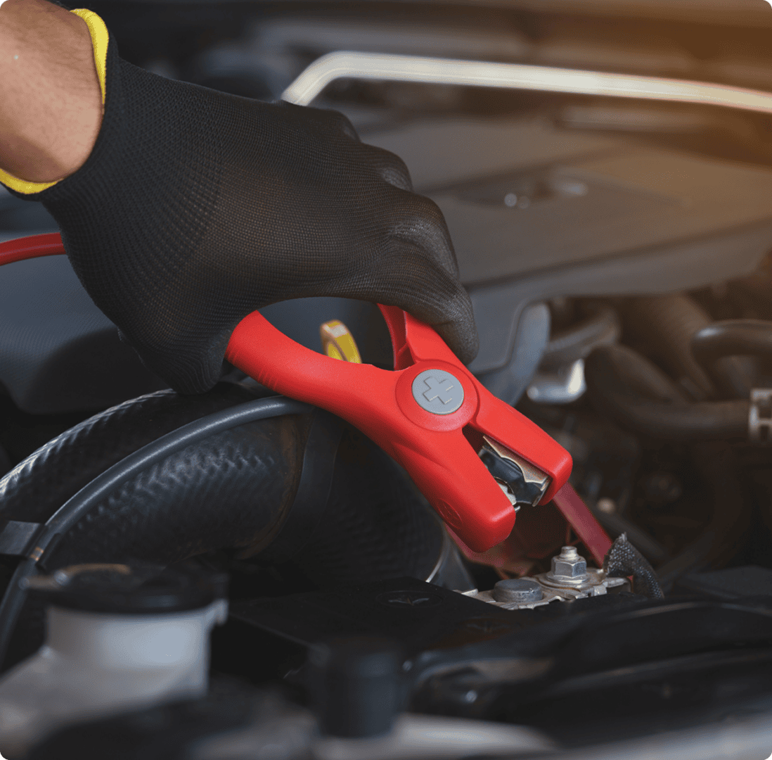 Jumper cables connecting car battery terminal.